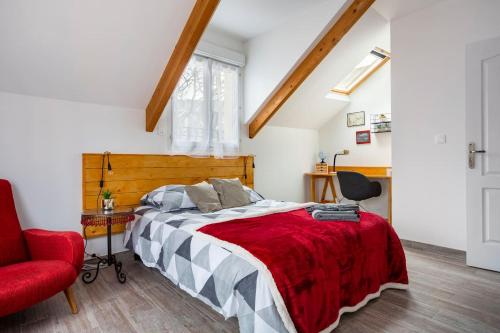 ein Schlafzimmer mit einem Bett und einem roten Stuhl in der Unterkunft Cosy House Near Paris 4 Bedrooms, Metro, Parking in Saint-Denis