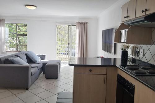 a kitchen and living room with a couch and a table at Spacious Hatfield Apartment in Pretoria