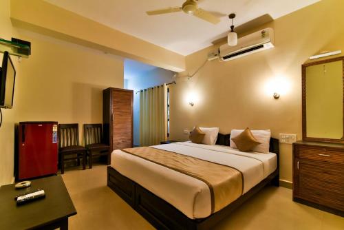 een slaapkamer met een groot bed in een kamer bij Baga Fantacia Beach Inn in Calangute