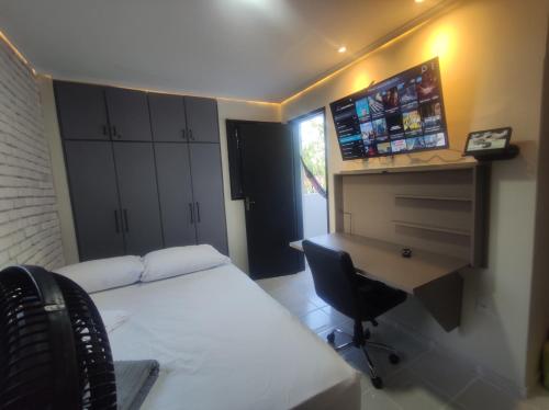 a bedroom with a bed and a desk and a computer at Praia do Bessa, Caribessa - Quarto Privativo - Conforto, Paz e Sossego, excelente para descansar, trabalhar ou estudar in João Pessoa