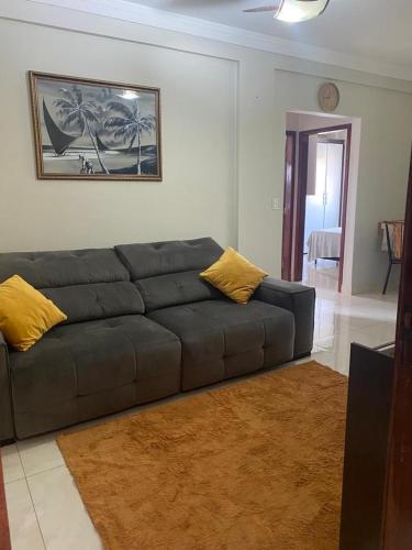 een woonkamer met een grijze bank en gele kussens bij Apartamento Day in Cuiabá
