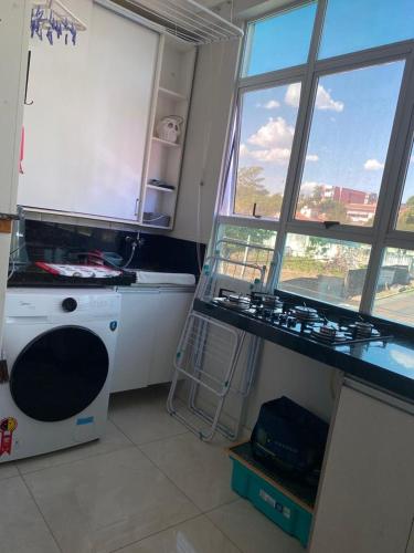 een keuken met een fornuis, een wastafel en ramen bij Apartamento Day in Cuiabá