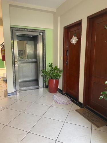 een hal met een deur en een potplant op de vloer bij Apartamento Day in Cuiabá
