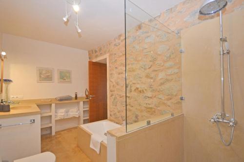Un baño con ducha con puerta de cristal. en Es Romegueral, en Artà