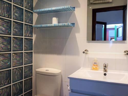 y baño con aseo, lavabo y espejo. en Can Tassi, en Porto Cristo