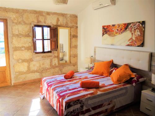 1 dormitorio con 1 cama con almohadas de color naranja en Casa Campet en Algaida