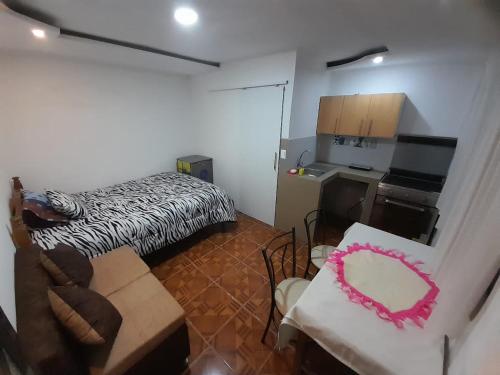 Kleines Zimmer mit einem Bett und einer Küche in der Unterkunft Casa campestre en las faldas del Taita Imbabura 3 in Otavalo