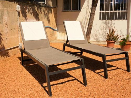 two chairs sitting next to each other on the ground at Ca sa comare in Llucmajor