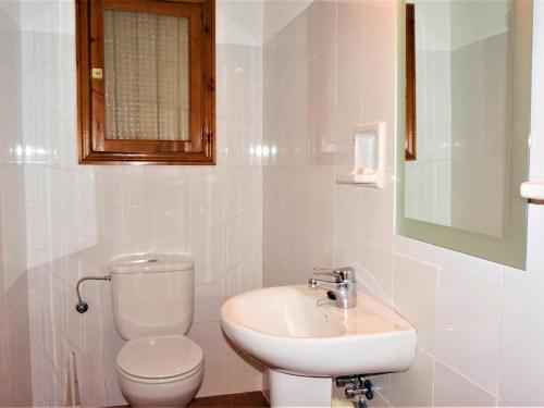 a white bathroom with a toilet and a sink at Ca sa comare in Llucmajor