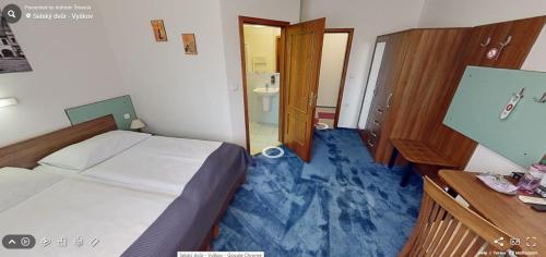 a small bedroom with a bed and a bathroom at Hotel Selsky Dvur in Vyškov