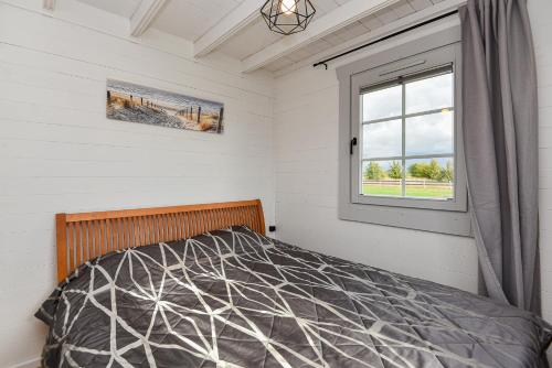 a bedroom with a bed and a window at Liepmalas - jaukus namukas Latvijos pajūryje in Nidden