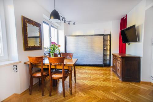 a dining room with a table and chairs and a television at Charming Apt next to Lazienki Park and City Center in Warsaw