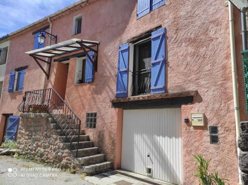 a red brick building with a door and stairs at Belle maison provençale in Castellane