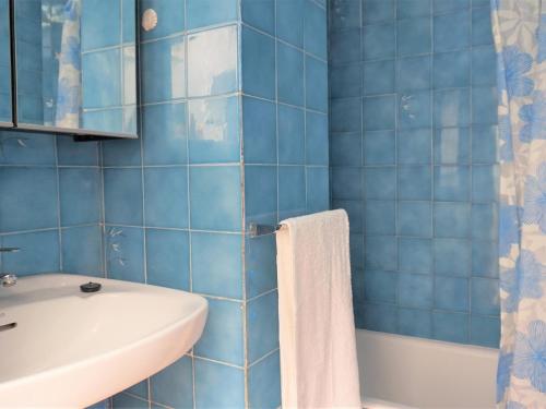 bagno piastrellato blu con lavandino e servizi igienici di Cas Bufador a S'Illot