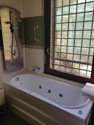 y baño con bañera y ventana. en EUR CHARME APARTMENT en Roma