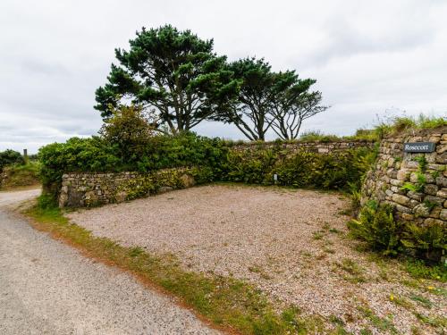a stone wall next to a dirt road at Rosecott in St Ives