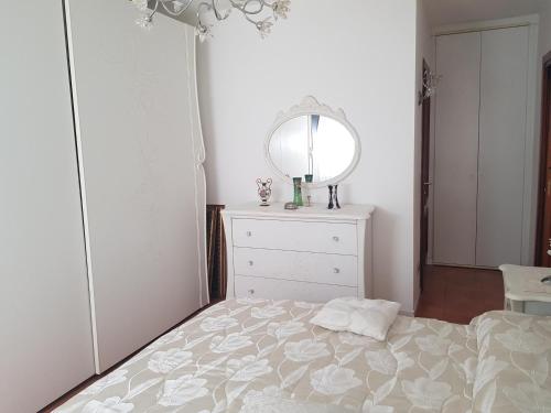 ein Schlafzimmer mit einem Bett mit einer Kommode und einem Spiegel in der Unterkunft EUR CHARME APARTMENT in Rom