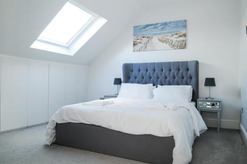 Un dormitorio con una cama grande y una ventana en Luxury 5 Star apartments, Parking, Garden, near Metro Stations 10-15mins to London, en Londres