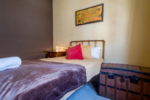 Un dormitorio con una cama con una almohada roja. en Casa Mox en la Sierra de las Nieves, Paraíso del Senderismo en Yunquera