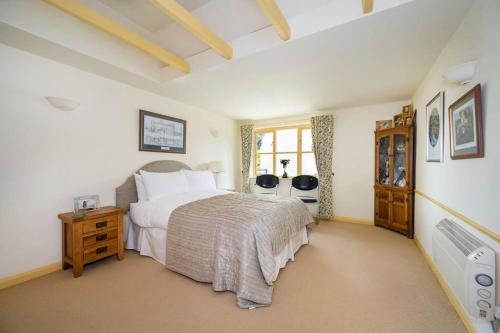 a bedroom with a large bed and a window at The Granary at Pannels Ash Farm in Sudbury
