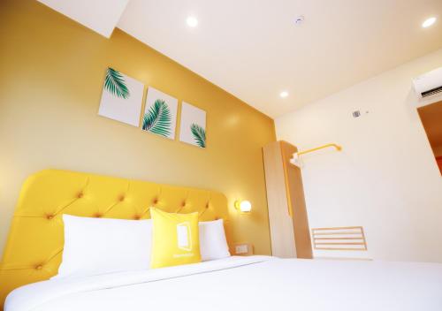 a bedroom with a large bed with a yellow headboard at Bloom Hotel - HSR Layout Sec 6 in Bengaluru