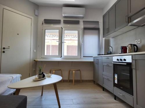 eine Küche mit einem Tisch und einem kleinen Tisch darin in der Unterkunft Little Fox Corfu 3 in Alepou