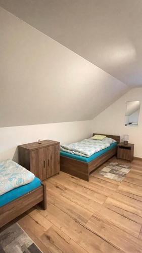 two beds in a room with wooden floors at Ubytovanie v Lihôtke in Oravský Podzámok