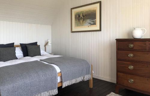 a bedroom with a bed and a dresser and a picture at Taigh Druim in Elgol