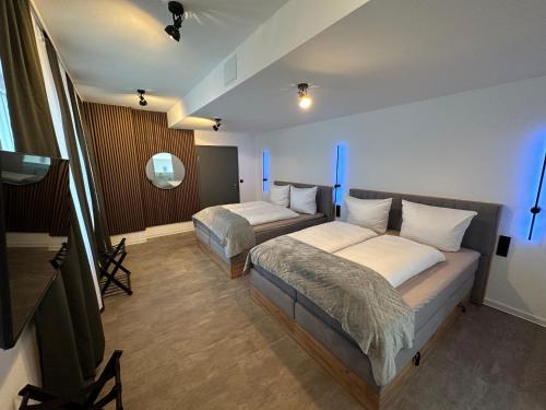a hotel room with two beds and a mirror at Hotel Emilia in Würzburg