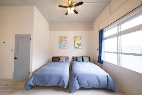 2 camas en un dormitorio con ventilador de techo en Panari, en Isla Miyako