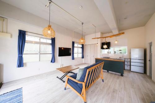 ein Wohnzimmer mit einem Tisch und einer Küche in der Unterkunft Panari in Miyako-jima