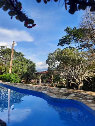 uitzicht op een zwembad met bomen op de achtergrond bij Sítio Vale da Serra in Maranguape