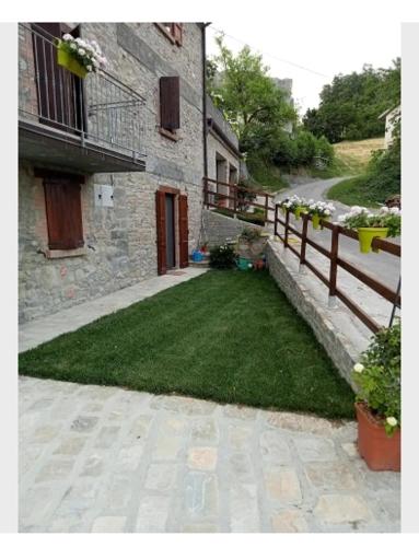 a yard with a fence next to a building at b&b La Divina Pietra in Carnola