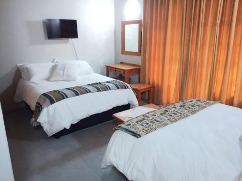 a hotel room with two beds and a television at Kataluma in Pretoria