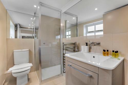 a bathroom with a toilet and a sink and a shower at Phaedrus Living: South Kensington Luxury Flat in London