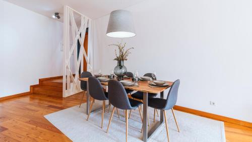 een eetkamer met een tafel en stoelen bij Mouzinho Downtown 2BR w/ parking by LovelyStay in Porto