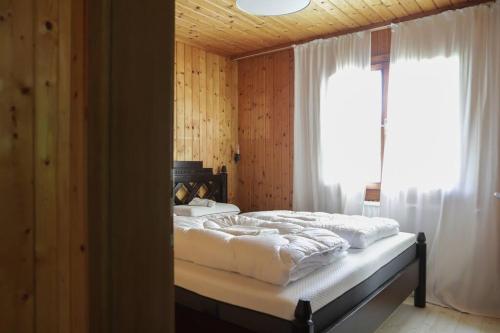 a bedroom with a bed with white sheets and a window at Scharnitz Chalet - gut eingerichtetes Haus in Scharnitz