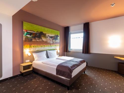 una habitación de hotel con una cama y un cuadro en la pared en B&B Hotel Mönchengladbach en Mönchengladbach