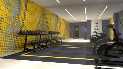 a gym with rows of benches and a yellow wall at Hampton By Hilton Szczecin East in Szczecin