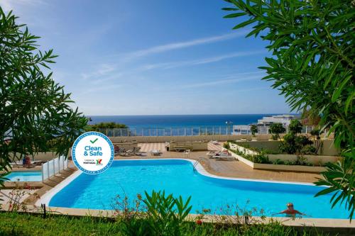 uma piscina com o oceano ao fundo em Florasol Residence Hotel - Dorisol hotels no Funchal