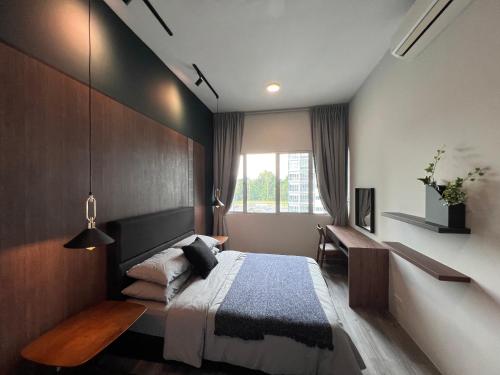 a bedroom with a bed and a desk and a window at Modern Stylish Apartment near Kuching Airport in Kuching