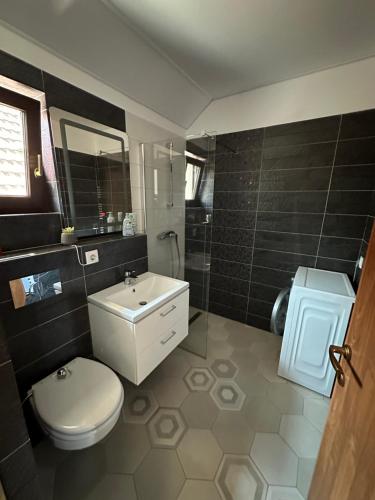 a bathroom with a white toilet and a sink at Bokorlak 3 in Odorheiu Secuiesc