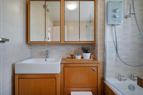 uma casa de banho com um lavatório, um WC e um espelho. em Modern House near Canary Wharf, Excel, Greenwich em Londres