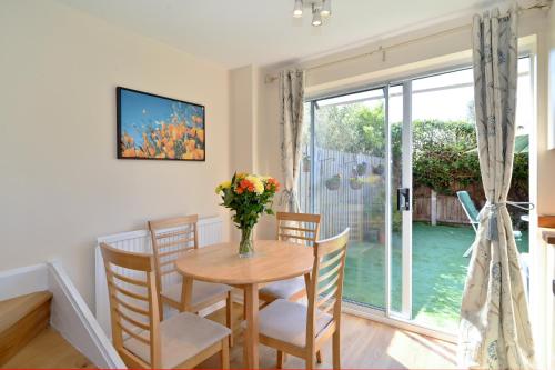 a dining room with a table and chairs and a window at Modern House near Canary Wharf, Excel, Greenwich in London