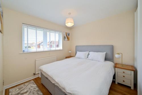 倫敦的住宿－Modern House near Canary Wharf, Excel, Greenwich，卧室设有一张白色大床和一扇窗户。