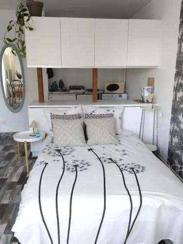 - une chambre avec un lit blanc et des armoires blanches dans l'établissement Studio Le Bonheur avec parking sous-sol privatif, à Chartres