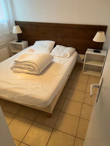 a bed with white sheets and pillows in a bedroom at Résidence Claire Rive in Prayssac