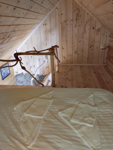 a bed in a room with a wooden wall at To Lem Ande in Lumshory