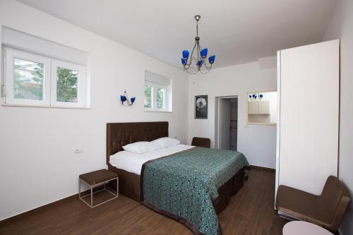 a bedroom with a bed with a green blanket at Aida Apartments and Rooms for couples and families FREE PARKING in Dubrovnik