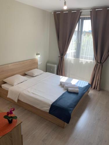 a bedroom with a large bed and a window at City Residence Apartments Sofia in Sofia